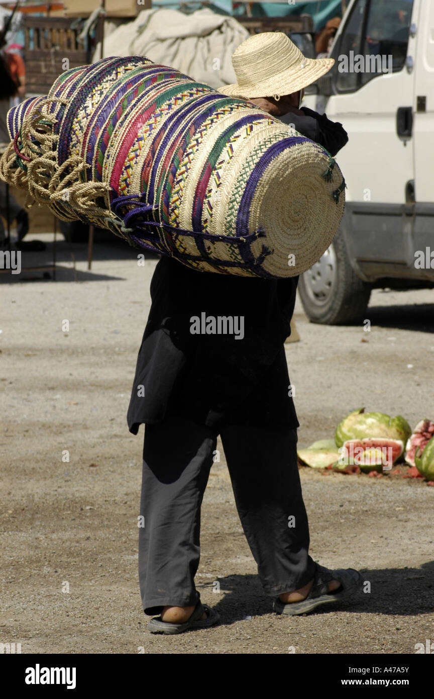 Un vannier à Nabeul, Tunisie, prend ses marchandises au marché sur son dos. Banque D'Images