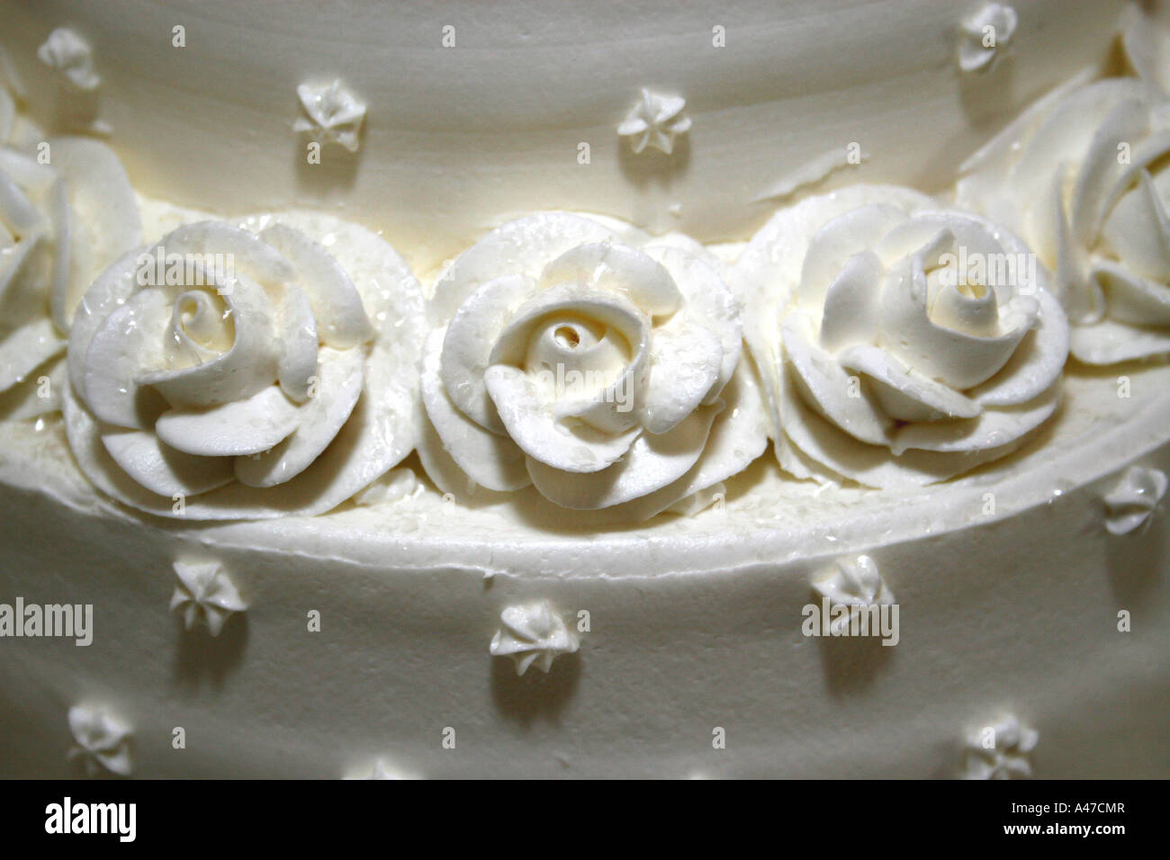 Des roses blanches à base de glaçage à gâteau sur un gâteau de mariage Banque D'Images