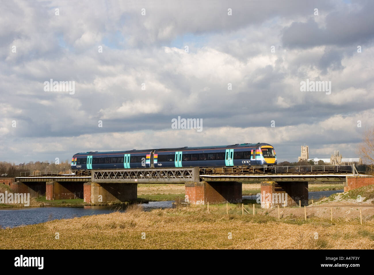 Une Anglia class 170 DMU No 170270 traversant un pont ferroviaire près de la jonction avec la station d'Ely Ely cathédrale en arrière-plan Banque D'Images