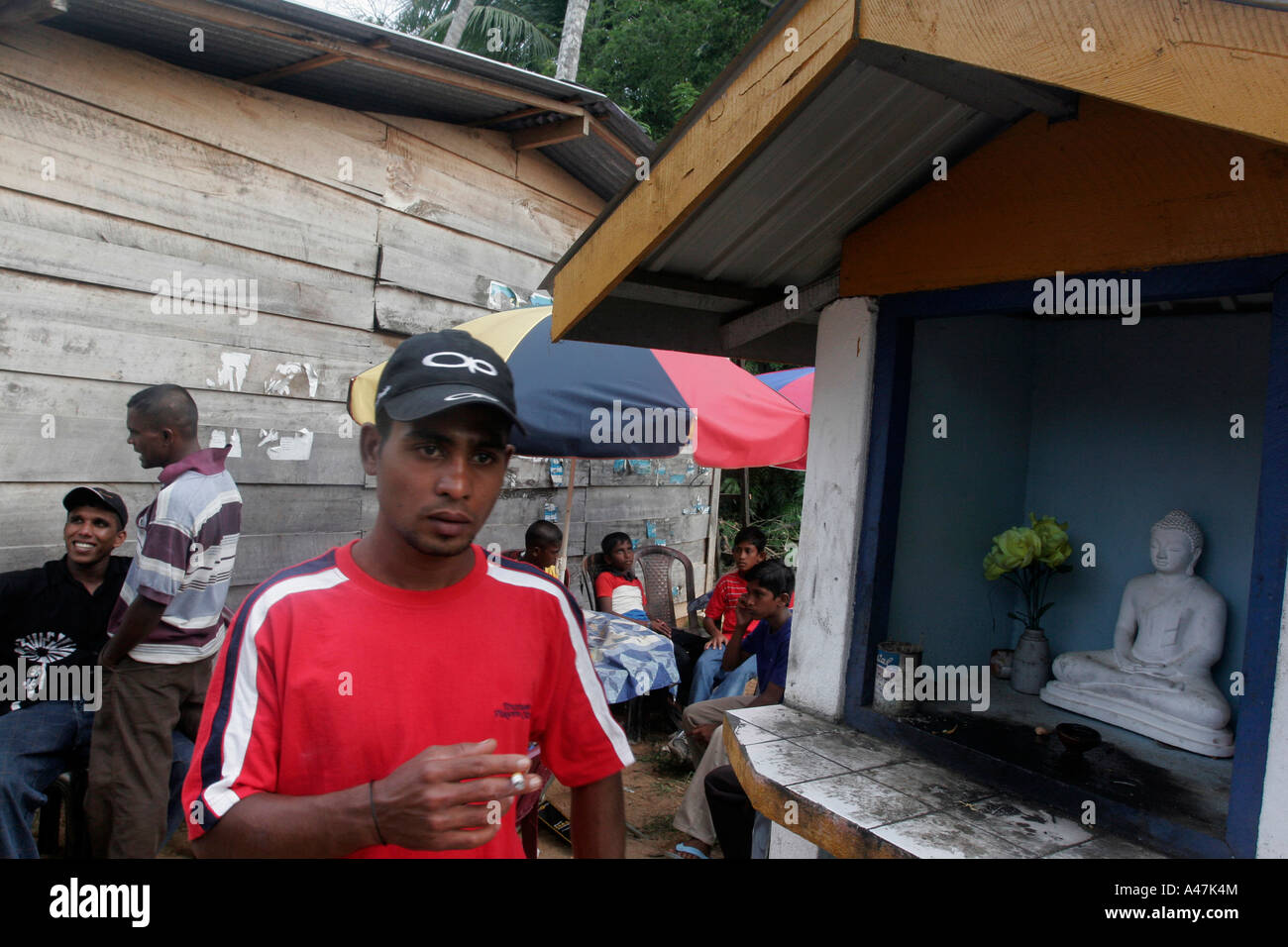 Les jeunes de se tenir près de l'autel d'un bouddha dans un camp construit pour les familles touchées par le tsunami au Sri Lanka Banque D'Images