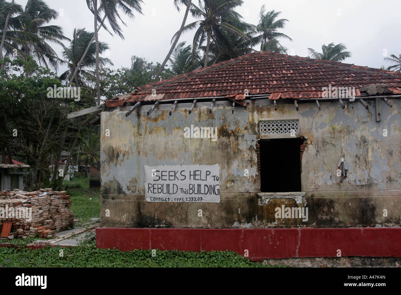 Les propriétaires d'une maison endommagée ont placé une affiche pour demander de l'aide à la reconstruction de leur maison au Sri Lanka Banque D'Images