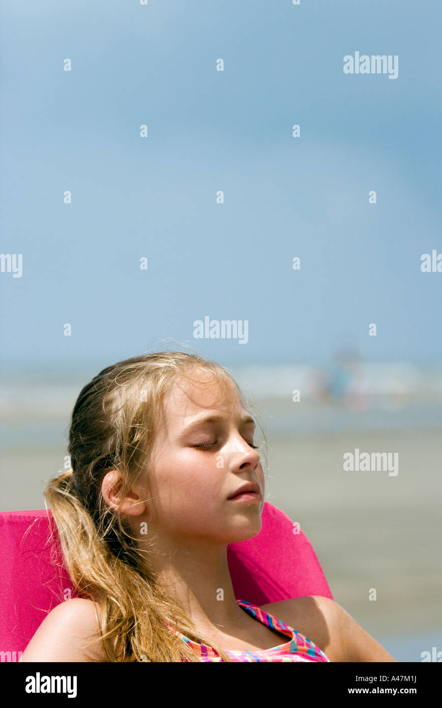 Girl relaxing in chair at beach Photo Stock - Alamy