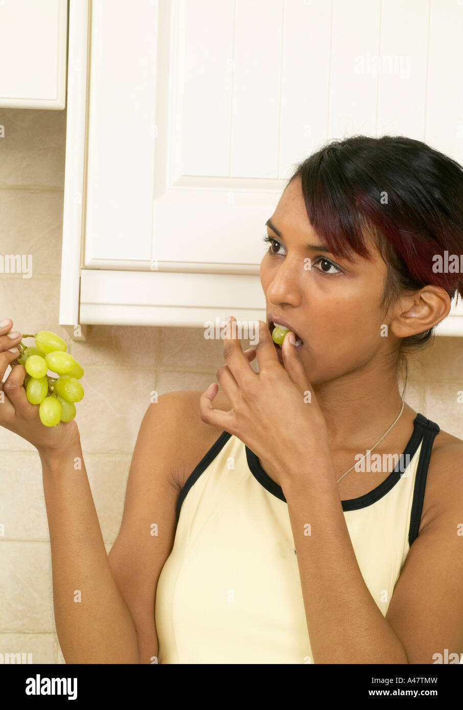 Belle jeune fille asiatique woman eating grapes Banque D'Images