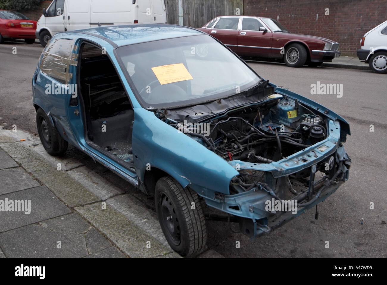 Vauxhall bleu abandonné et vandalisé des pièces de voiture accidentée à gauche sur la banlieue de Londres avec l'élimination de la rue Conseil d'avertissement Banque D'Images