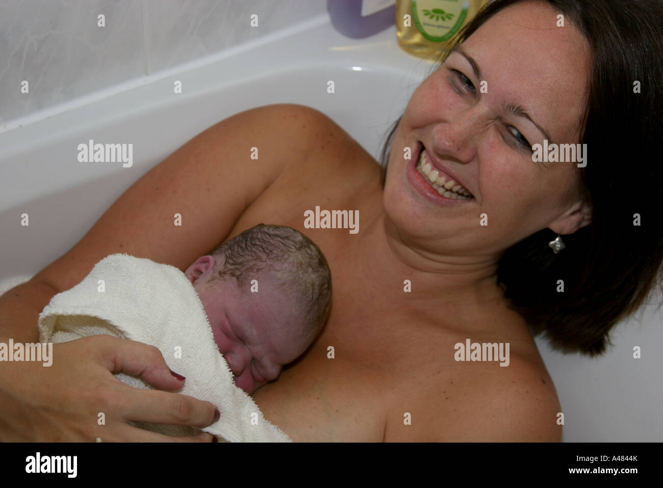 Bébé nouveau-né immédiatement après l'accouchement dans une baignoire d'accueil Banque D'Images