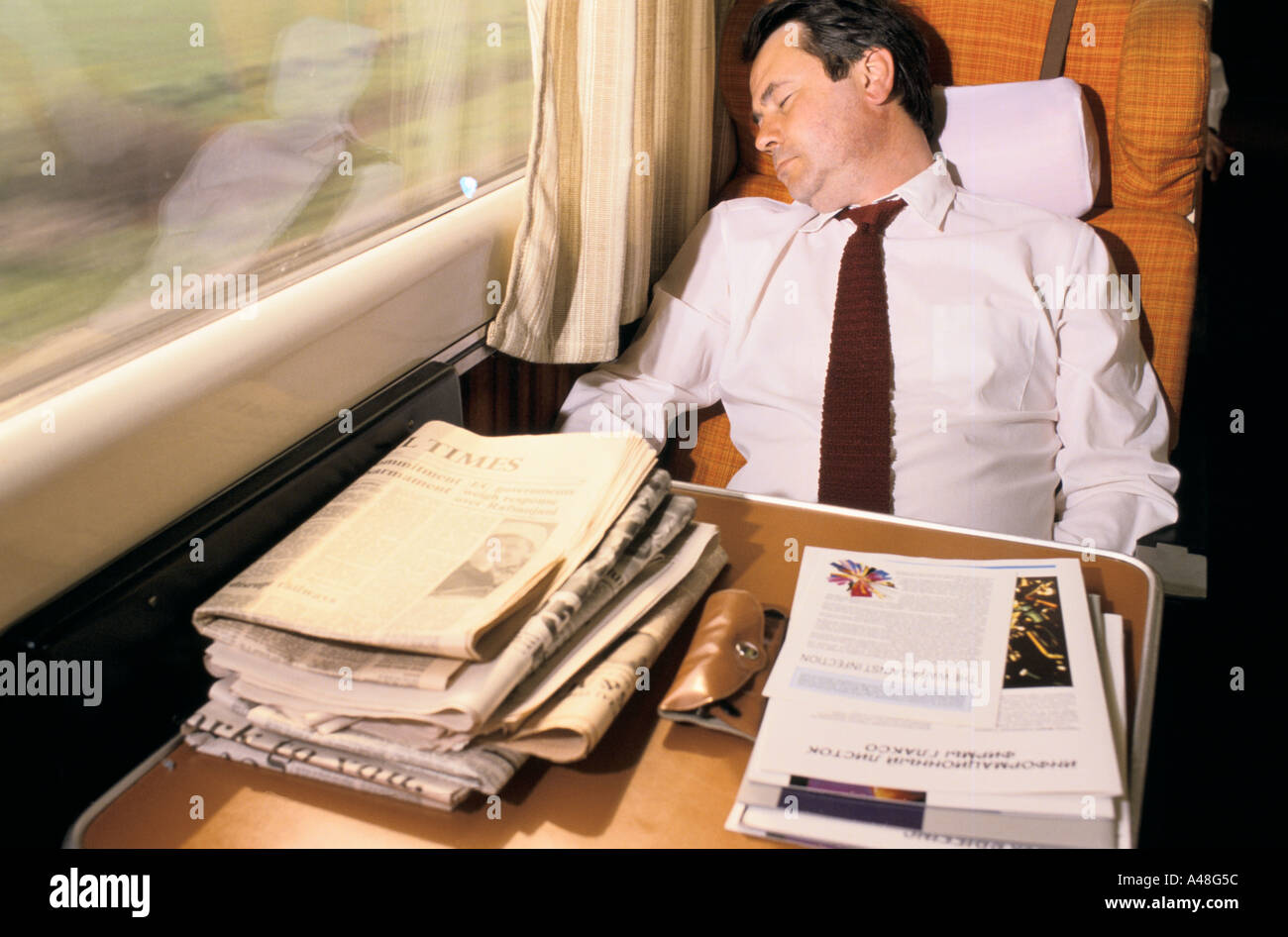 Businessman russe endormi sur le train Grande-Bretagne Banque D'Images