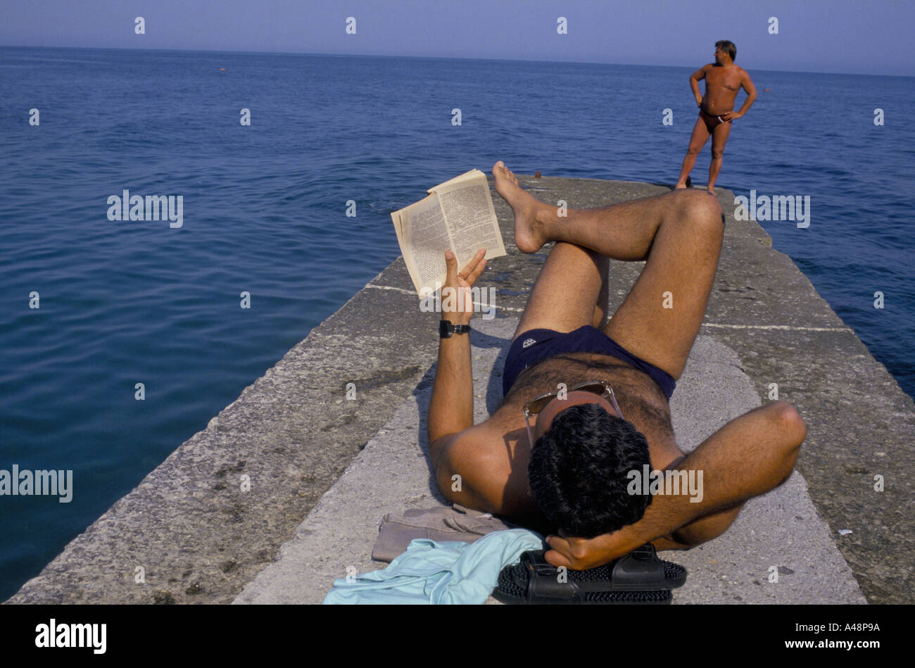 Un vacancier lecture et d''un bain de soleil sur le front de mer de Yalta. Ukraine Crimée Banque D'Images
