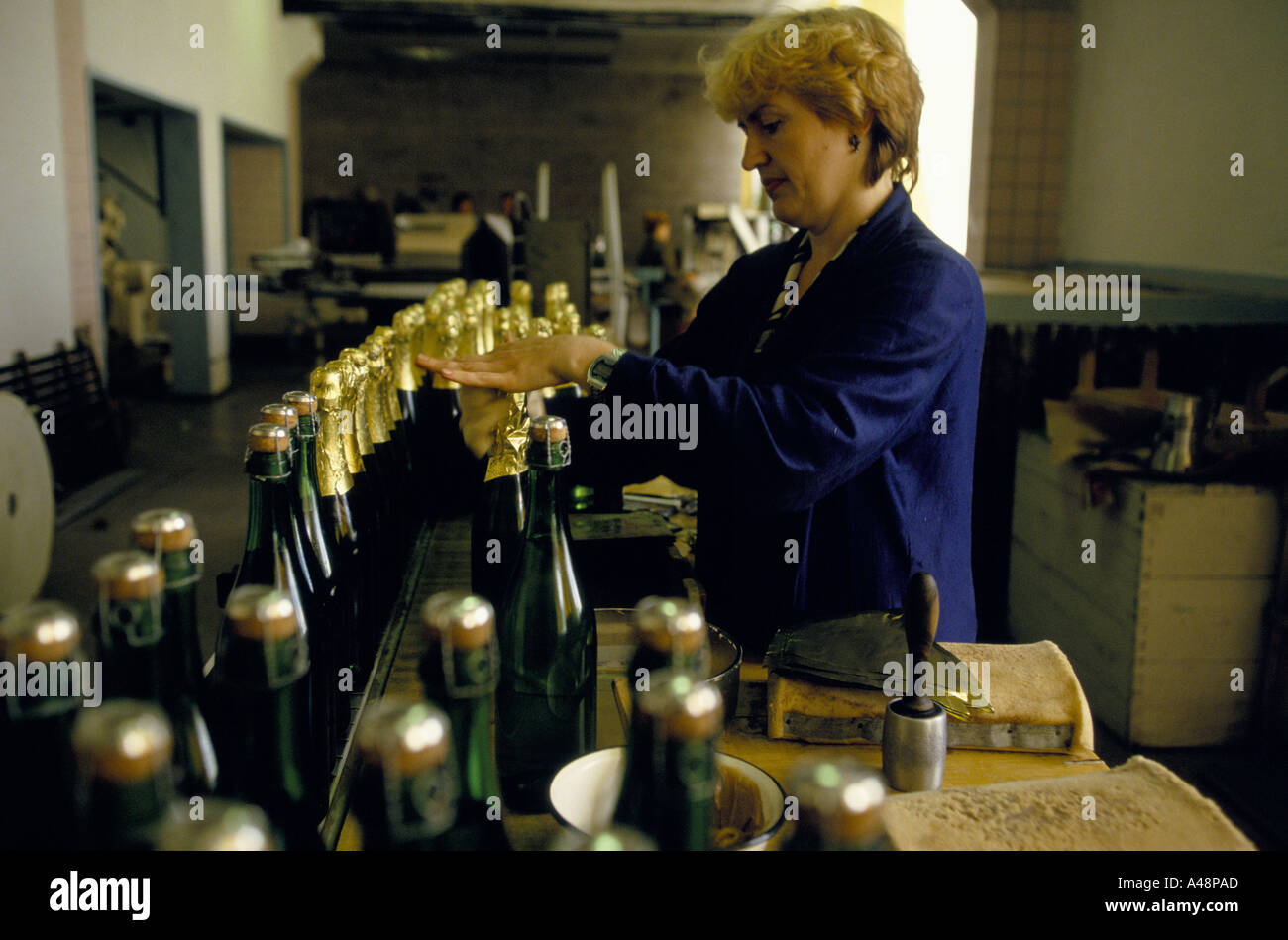 Mettre femme tops d'aluminium sur des bouteilles de vin. Ukraine Crimée Sudak Banque D'Images