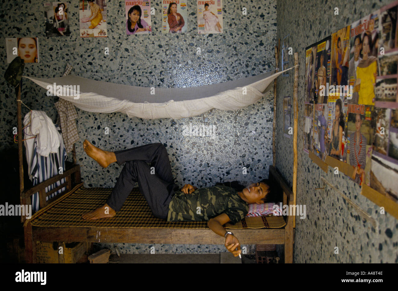 Un garde se trouve sur son lit de fumer à bord de l'Sihanouks accueil à Kampot Cambodge Banque D'Images