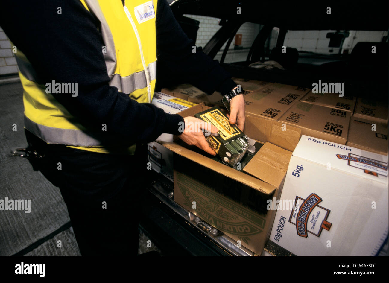 Un AGENT DES DOUANES ET ACCISE, port de Douvres SUR LA CÔTE SUD DE L'ANGLETERRE on confisque les biens des catalogues d'un passeur. Banque D'Images