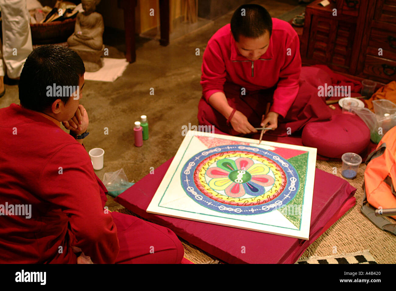 Deux moines tibétains travaillant sur un mandala de sable Banque D'Images