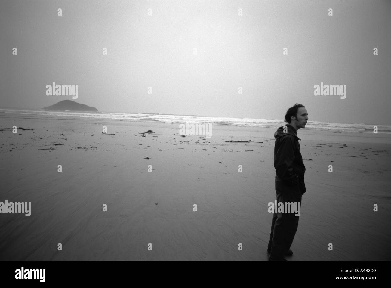 Un homme debout seul sur une plage dans le parc national Pacific Rim de l'île de Vancouver, Canada Banque D'Images