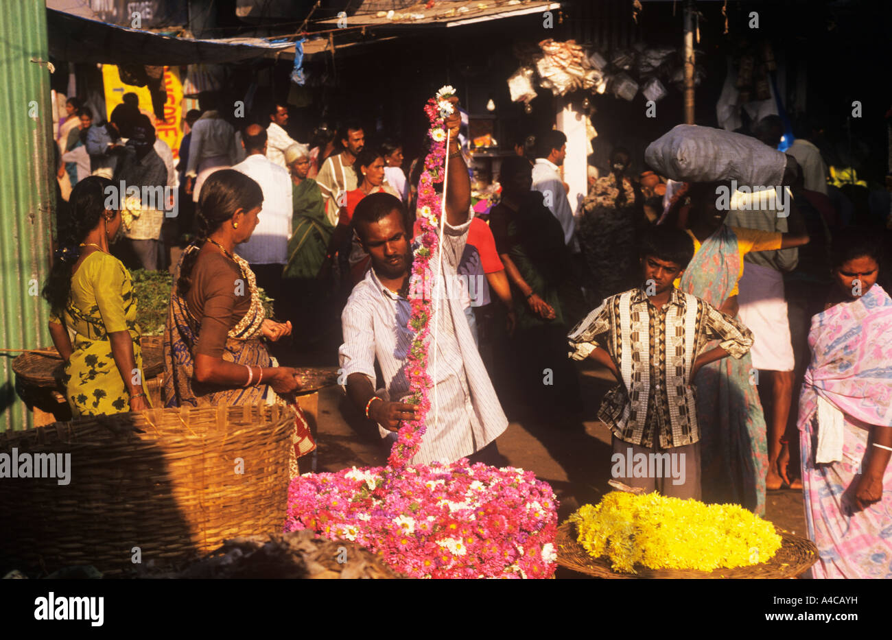 L'homme vend des guirlandes de fleurs Devaraja Market Mysore, Karnataka, Inde Banque D'Images
