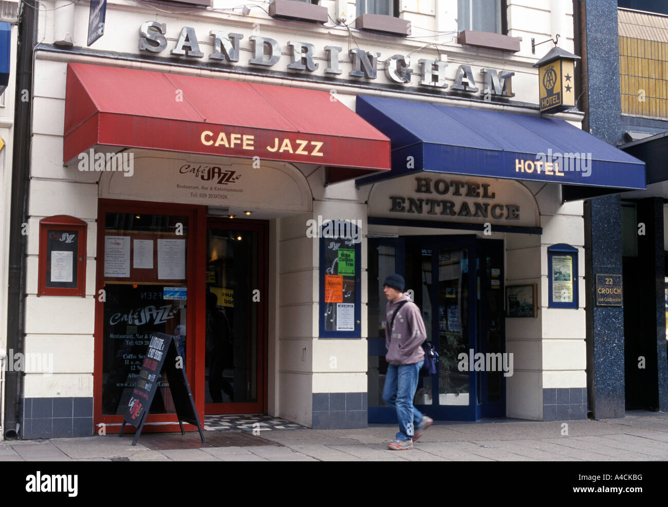 Homme marchant le long de la rue de Cardiff a adopté l'hôtel Sandringham et bar Banque D'Images