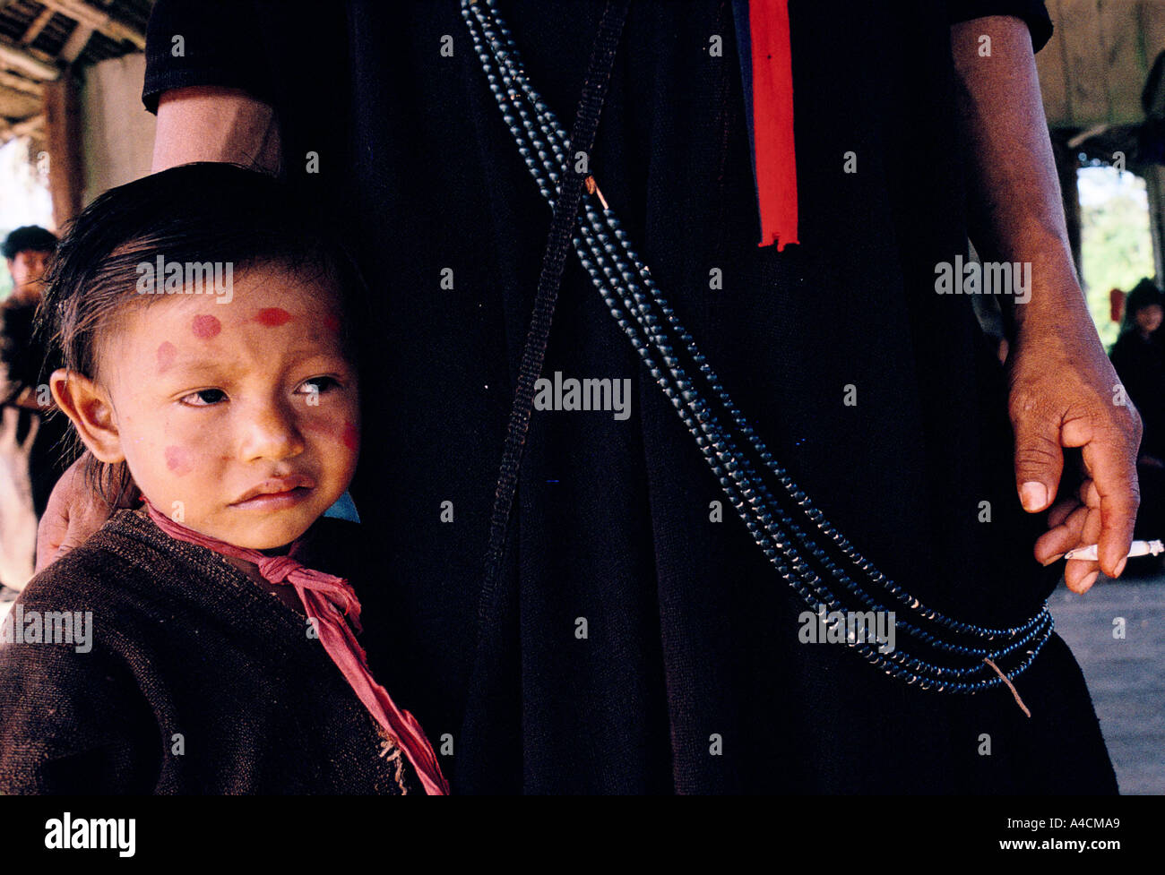 Indiens Ashaninka, province d'Acre, forêt amazonienne, Brésil : un enfant Ashaninka est réconforté par son père après avoir reçu une injection de vaccin de l'un des agents de santé de Maria Bittencour, avec l'association caritative britannique Health Unlimited. Les Indiens Ashaninka appliquent de la peinture faciale chaque jour, dans un design qui reflète leur humeur. Fabriquée à partir des graines de la plante Urucum, la peinture a une couleur rouge riche. Parfois, ils utilisent également le noir de feu pour les détails. Les garçons prennent autant soin de leur apparence que les filles. Banque D'Images
