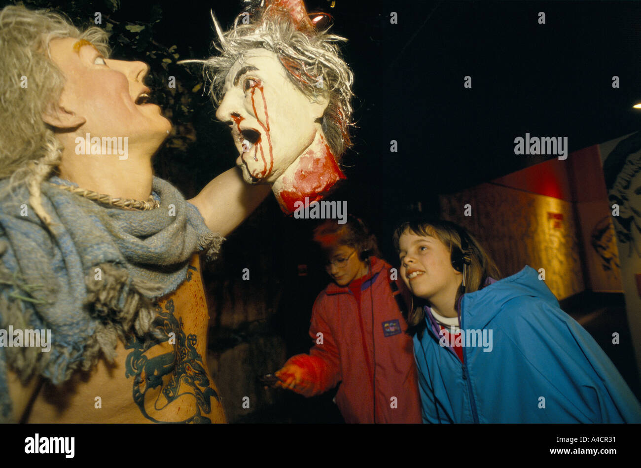 Les ENFANTS À LA RECHERCHE D'AFFICHAGE AU DRUID RITUELS, homme tenant une tête de saignement. Les falaises blanches de Douvres, l'expérience, en Angleterre, Mars 1994 Banque D'Images