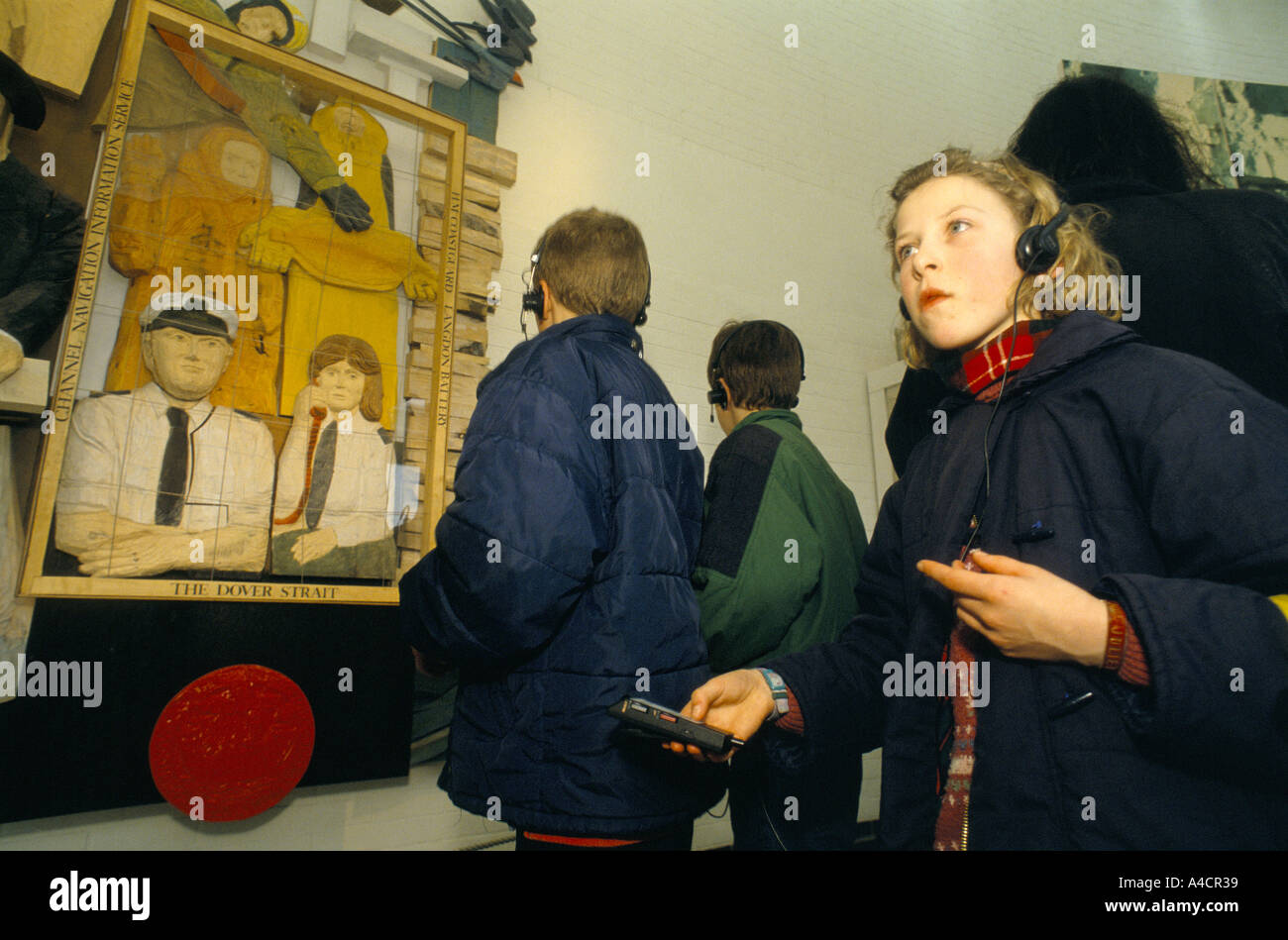 Les ENFANTS À LA RECHERCHE DE L'AFFICHAGE À L'EXPÉRIENCE DES FALAISES BLANCHES AVEC L'AIDE D'AUDIIO GUIDE & CASQUE. Douvres, Angleterre, Mars 1994 Banque D'Images