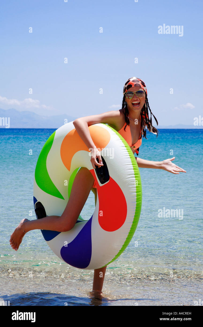 Jeune femme sur la plage avec anneau de sauvetage gonflable Banque D'Images