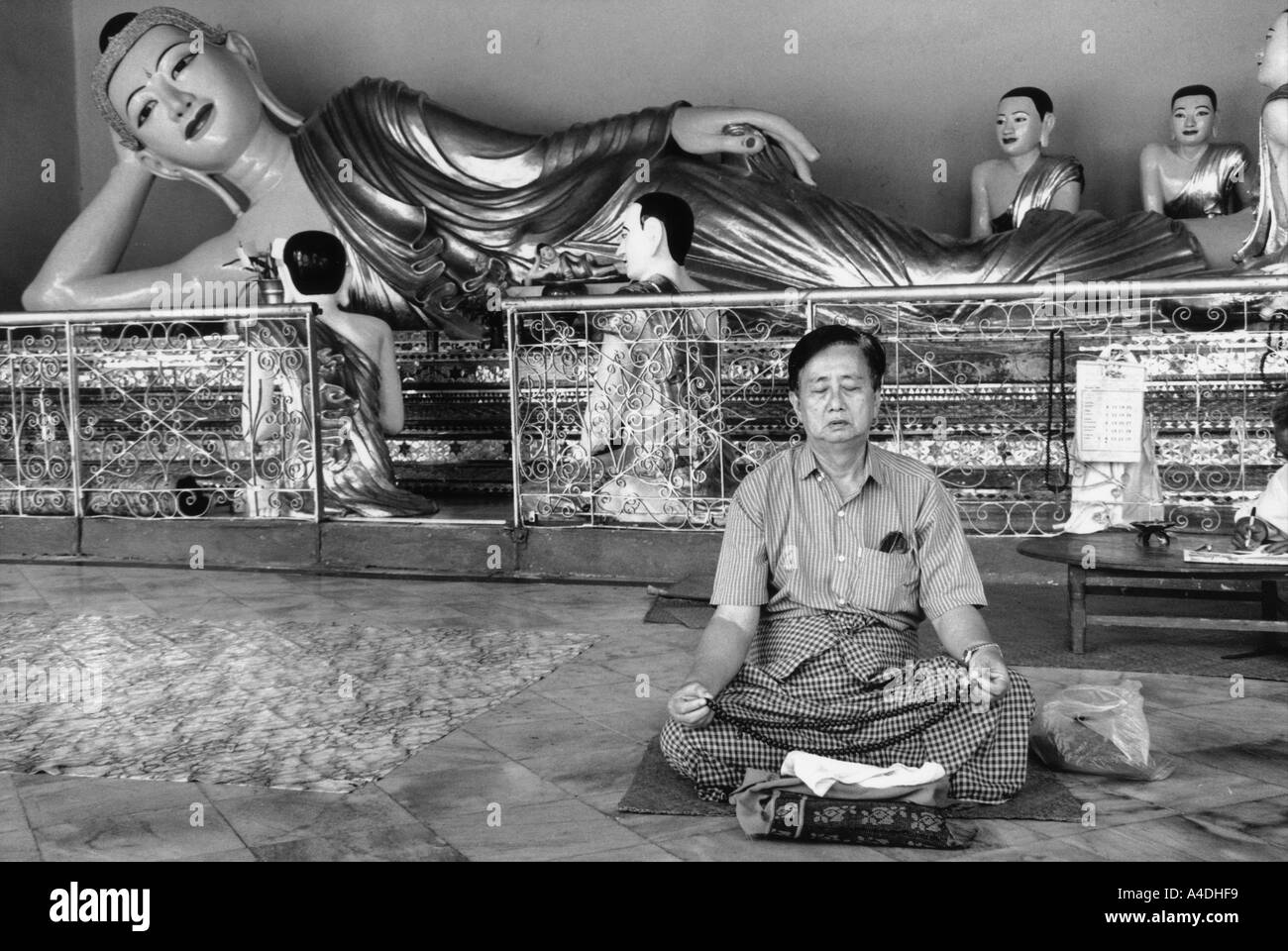 Un homme priant devant un Buddah au Temple Shwedagon Paya, Yangon, Rangoon, Myanmar, Birmanie Banque D'Images