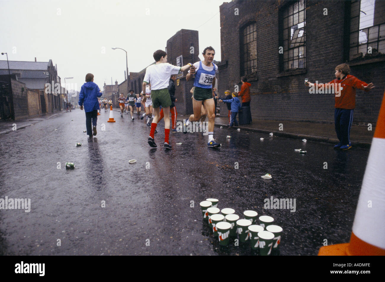 Les enfants de donner des verres d'eau aux coureurs pendant le marathon de Londres Banque D'Images