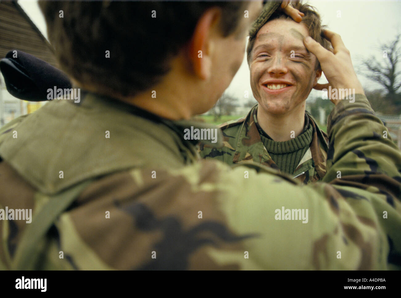 Membre de la Royal Berkshire et Stratford groupes survivaliste application peinture camouflage face à un collègue son front. Banque D'Images