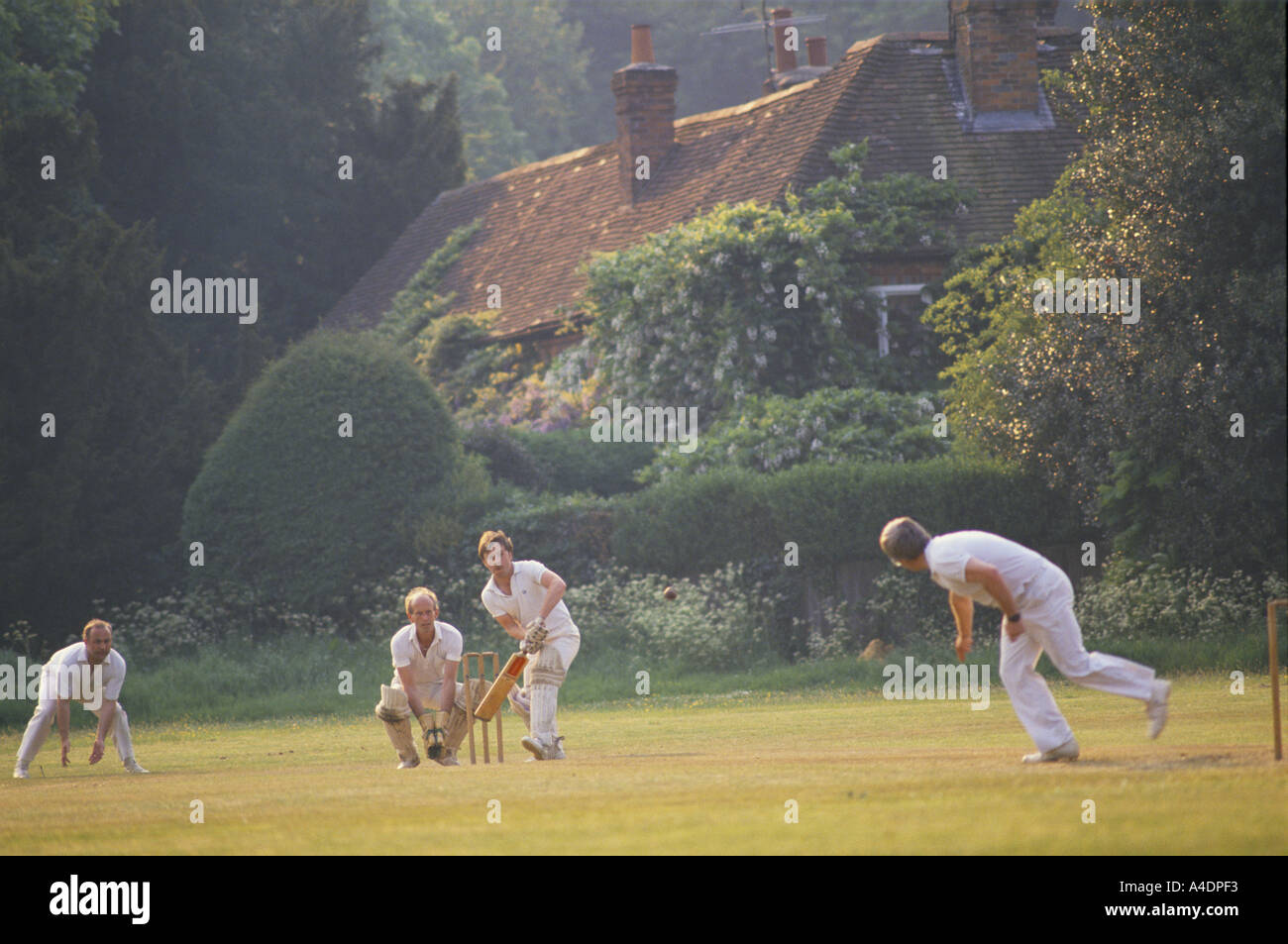 Men playing cricket village, UK Banque D'Images