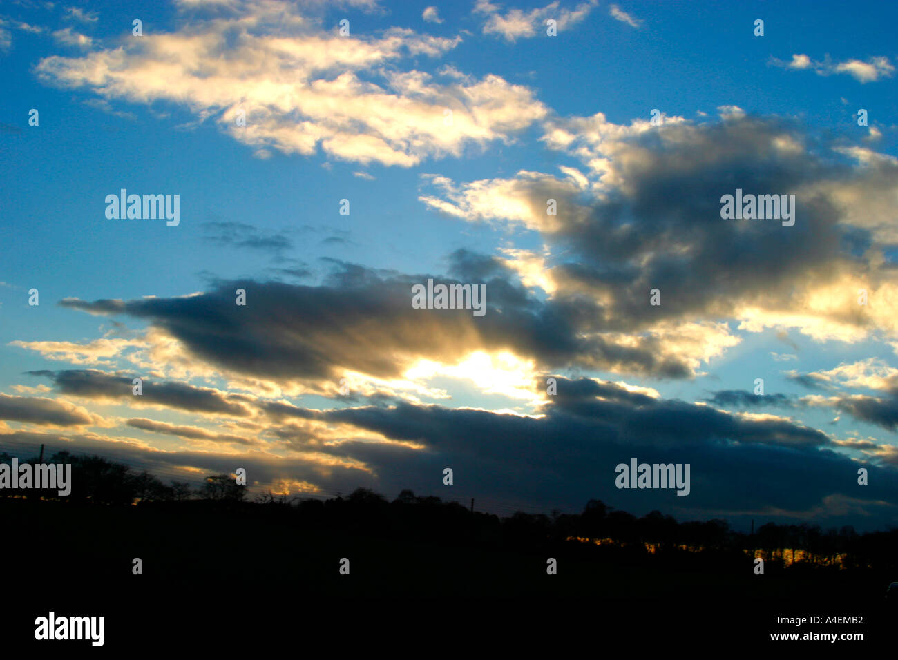 Moody ciel avec nuages et soleil partiellement obscurci Banque D'Images