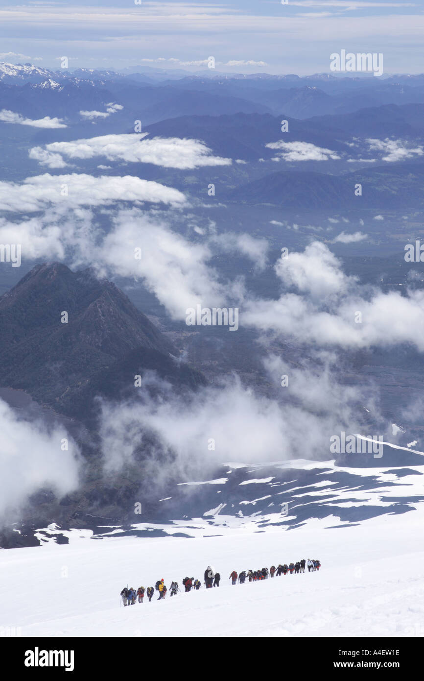 Les randonneurs touristes escalade vers le cratère du volcan couvert de neige Pozzuoli près de La Araucania Pucon Chili Lake District Banque D'Images