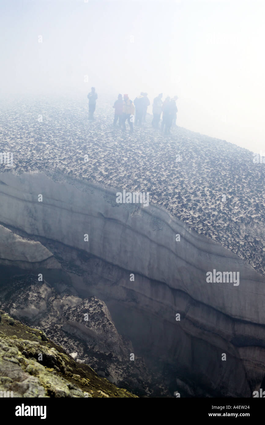 Les touristes se pencher sur le cratère sulfureux smoky nuageux du Volcan Villarrica La Araucania Pucon Chili Lake District Banque D'Images