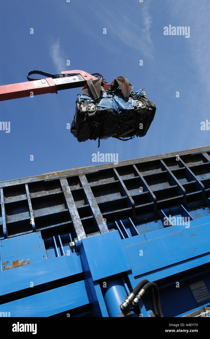 Une voiture écrasée est soulevée par une grue après avoir été écrasé à une casse. Banque D'Images