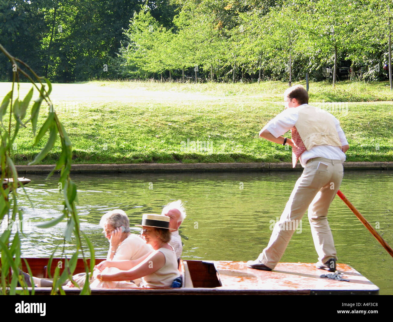 Punir sur la River Cam, femme utilisant le téléphone mobile, le dos, Cambridge, Cambridgeshire, Angleterre, Royaume-Uni Banque D'Images