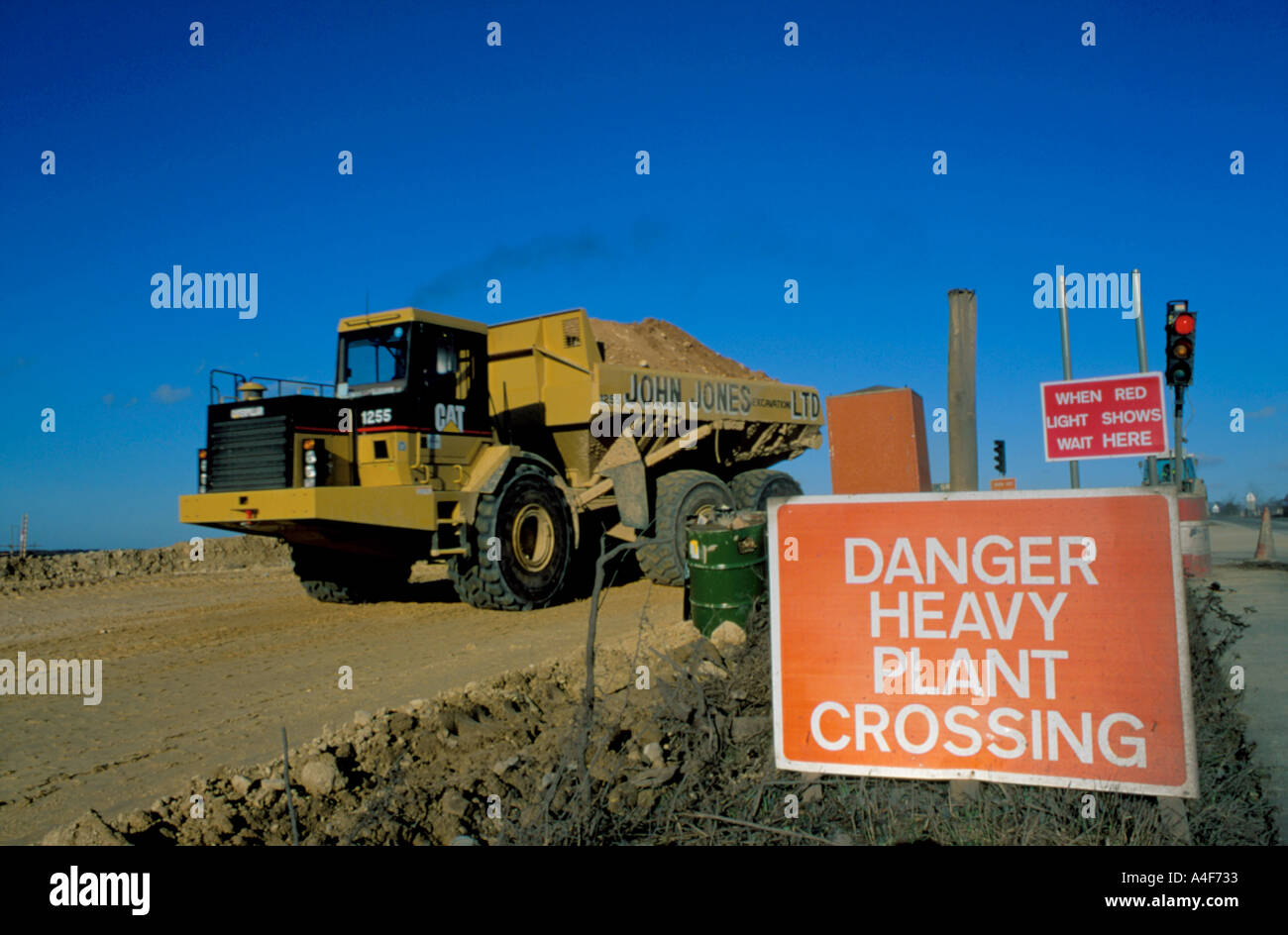 "Danger des passages à niveau l'usine' signe, avec CAT dump truck au-delà. Banque D'Images