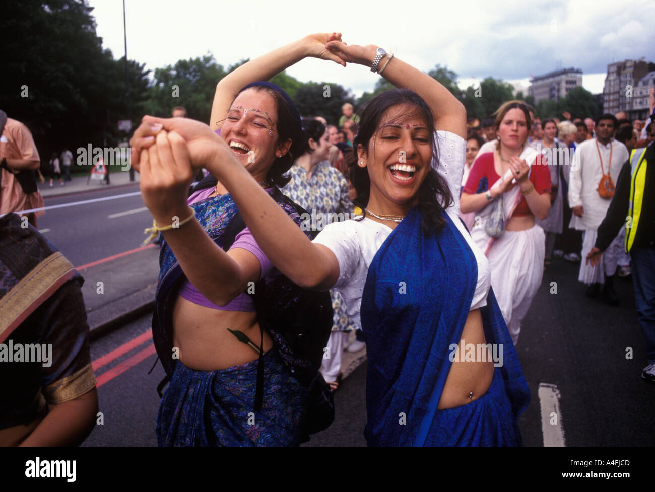 Adolescentes jeunes femmes festival hindou de Londres a mélangé des personnes ethniques diverses. Hare Krishna les dévots de Krishna dansent vers le bas Park Lane Londres Angleterre 2004 Royaume-Uni. Banque D'Images