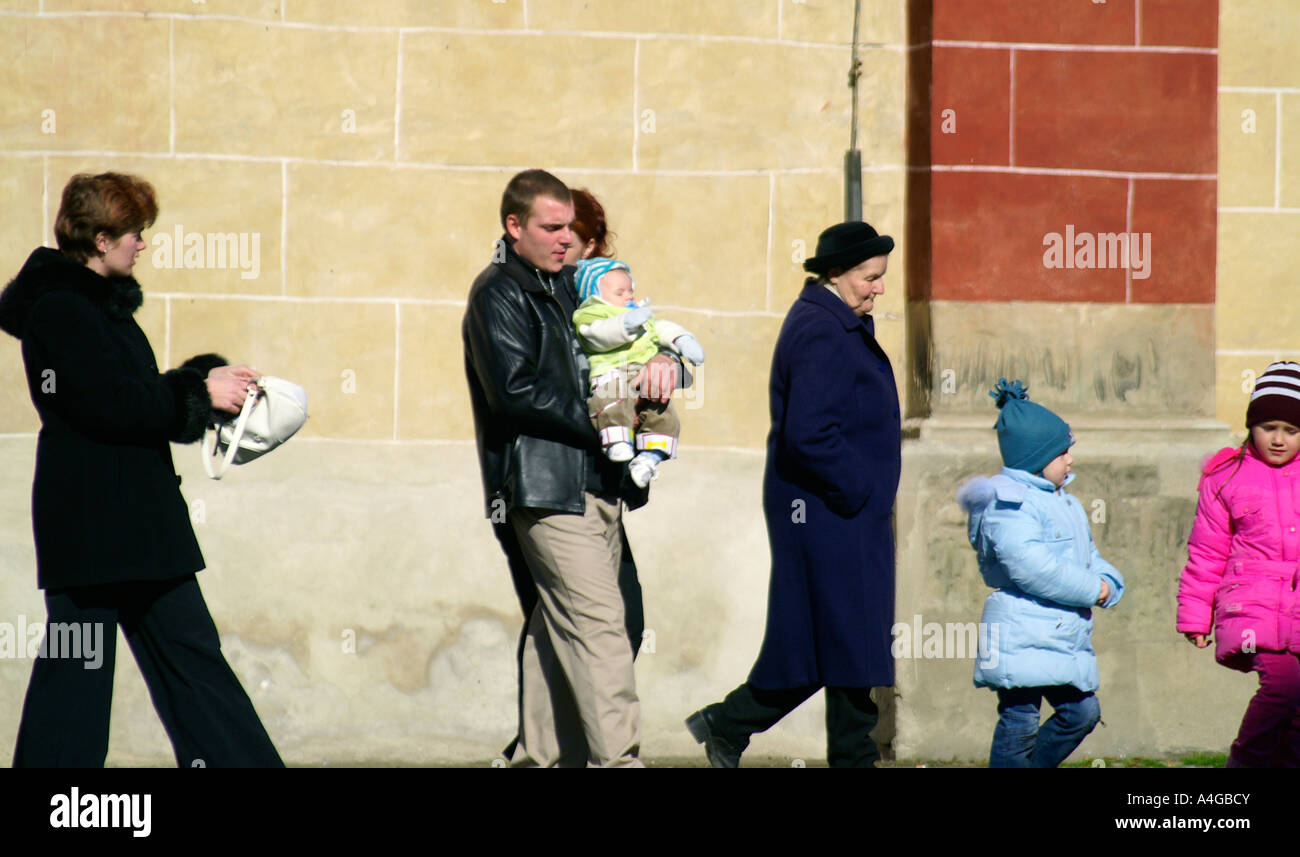 Ligne de personnes à pied en face de l'église de mur à Banska Bystrica, Slovaquie Banque D'Images