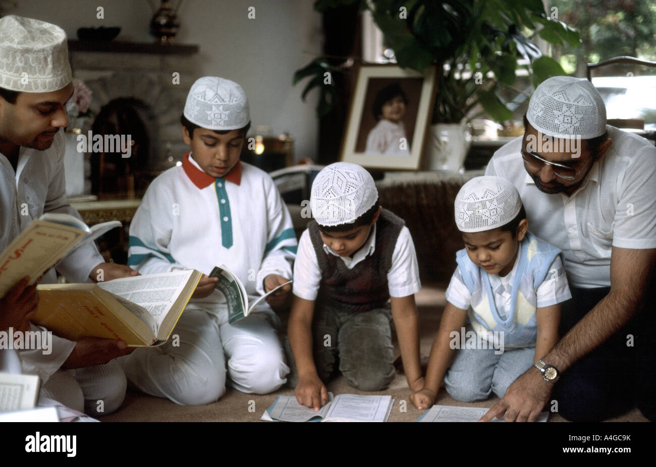 Les hommes musulmans en prière avec leur fils dans leur maison pour célébrer la fin du Ramadan Banque D'Images