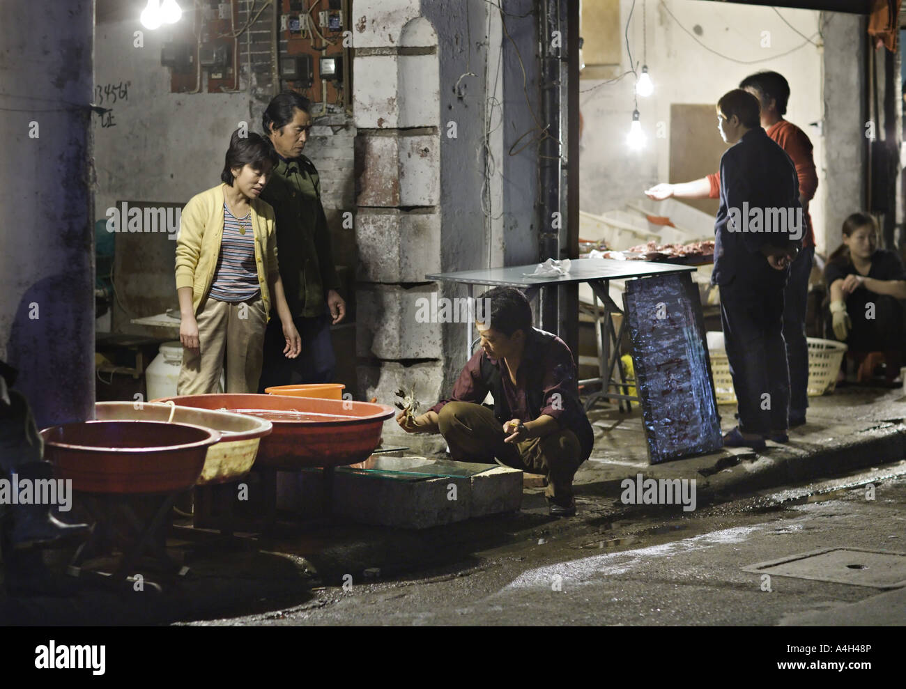 Chine SHANGHAI des acheteurs et vendeurs de négocier les prix à un marché nocturne dans le quartier de Shanghai Banque D'Images