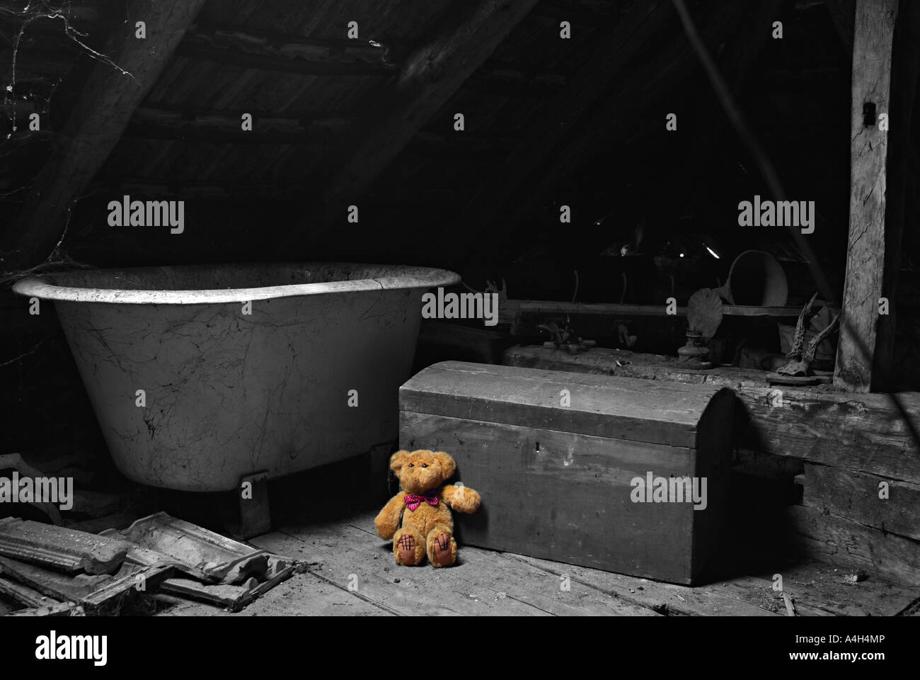 Ours en peluche oublié gauche contre un vieux coffre de jouet dans un grenier poussiéreux Image en noir et blanc colorisée Banque D'Images