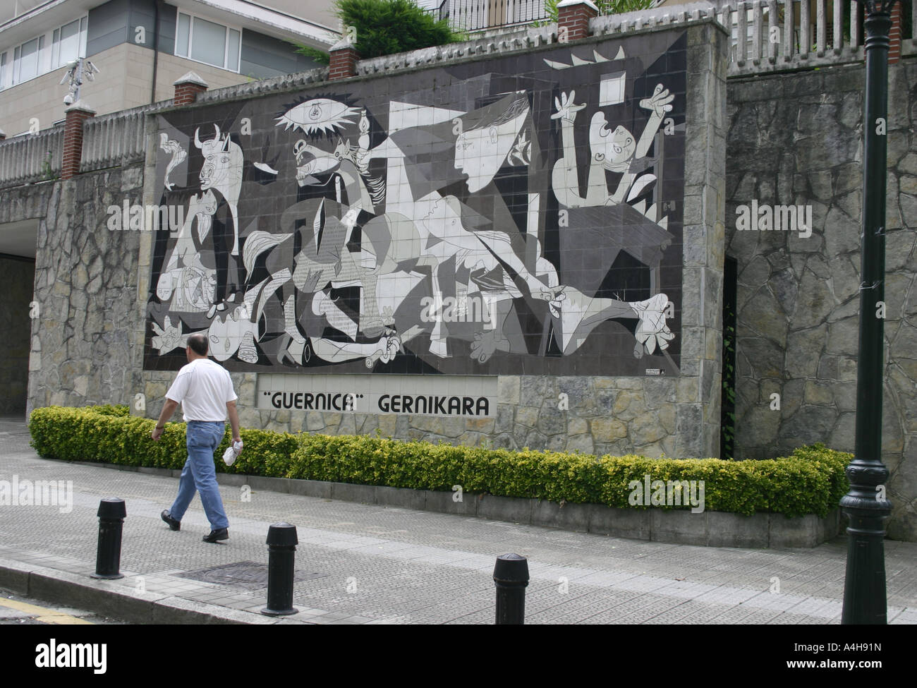 Homme marchant devant la fresque murale de la rue de Picasso Guernica dans la ville de Guernica, Gascogne, pays Basque, Espagne Banque D'Images