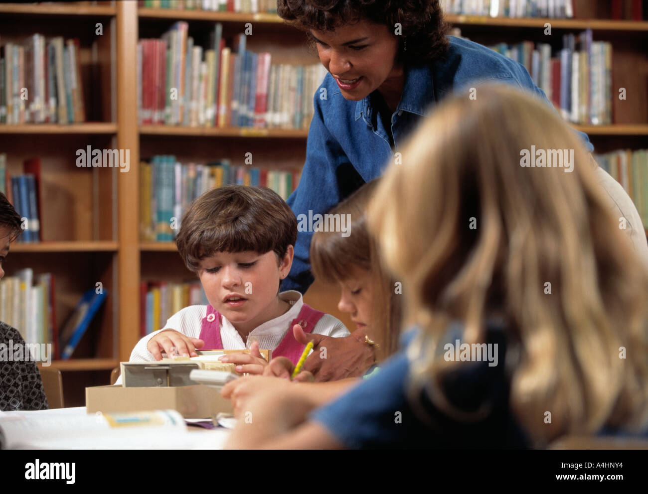 Aider les élèves féminins minoritaires dans bibliothèque de l'école Banque D'Images