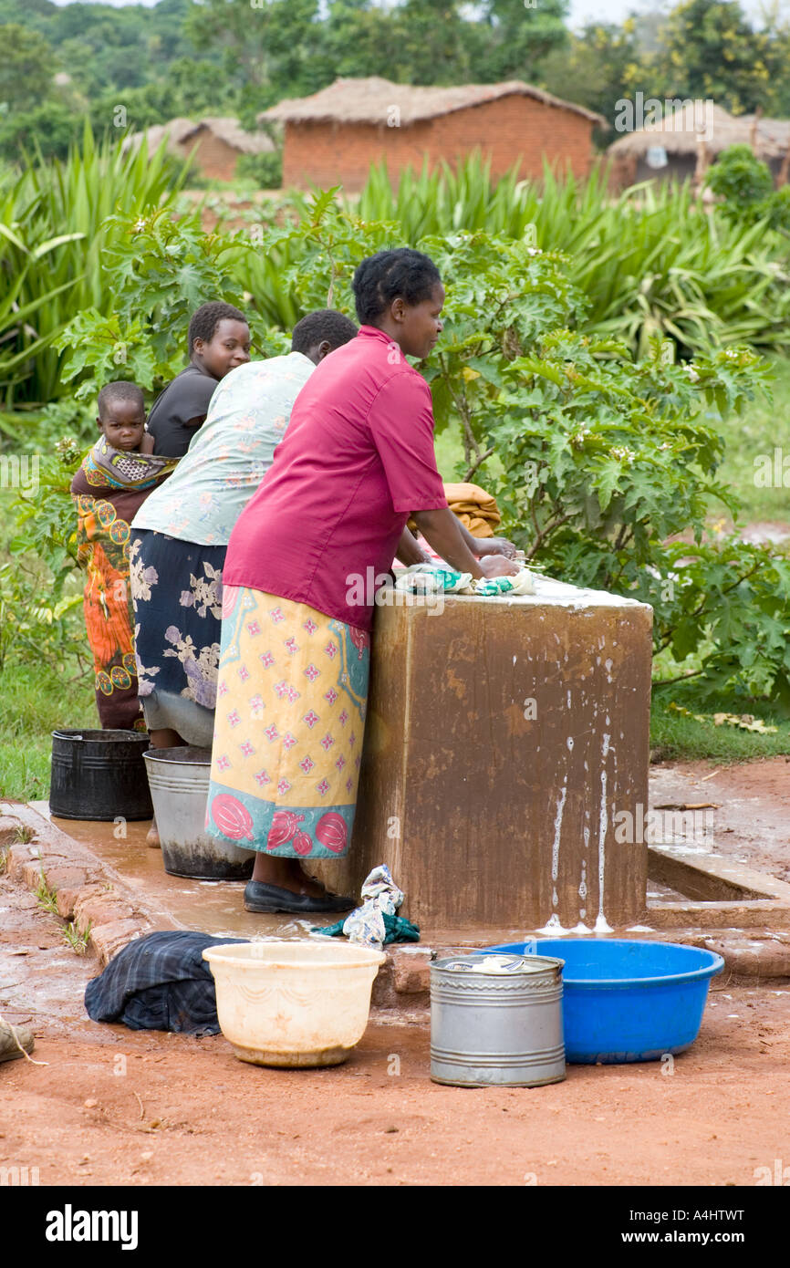 Les femmes qui font la vaisselle dans le village d'Chagamba Afrique Malawi Banque D'Images