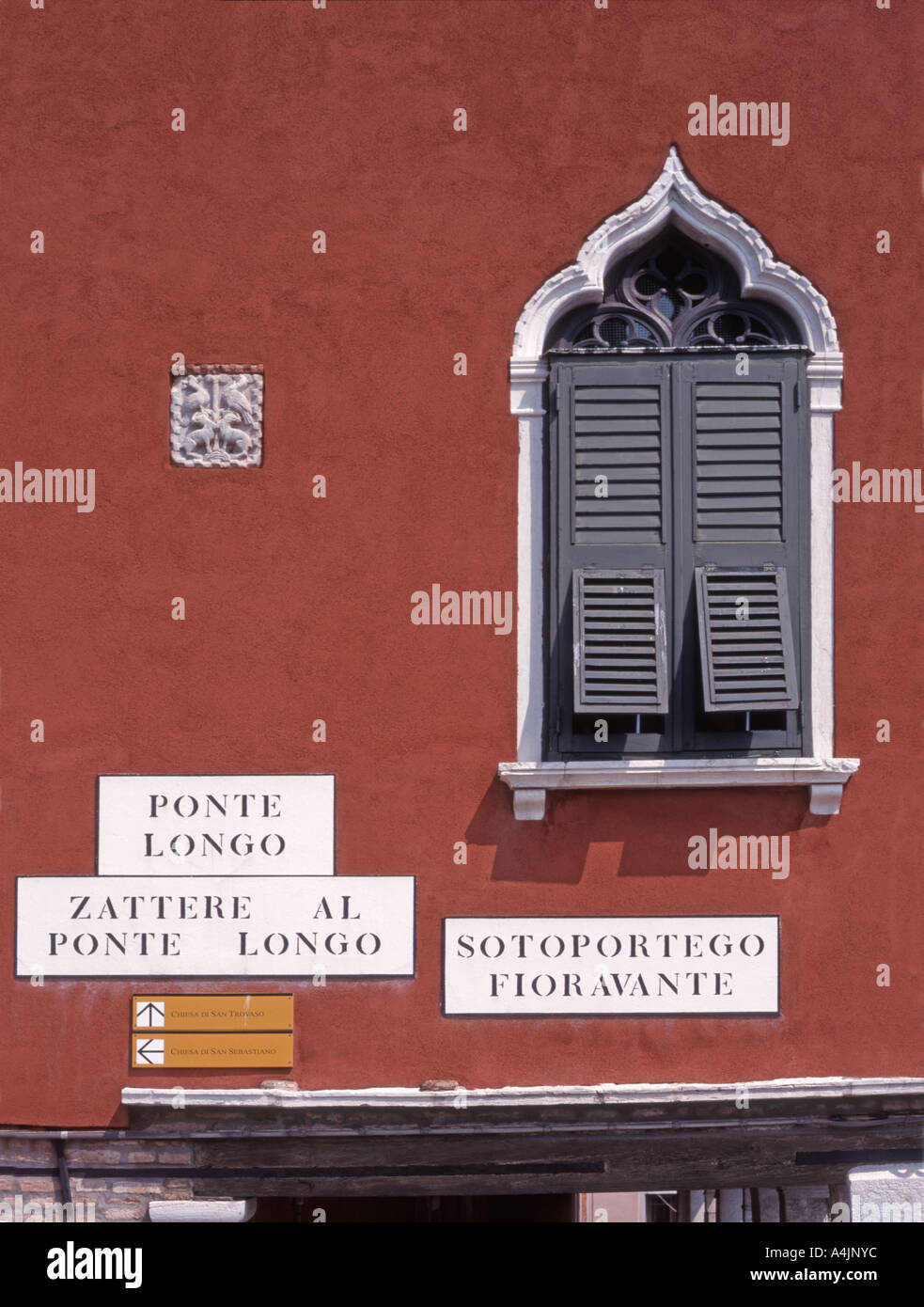 Venise, Vénétie, Italie. Maison typique avec détail fenêtre vénitienne, les plaques de rue et les orientations vers des lieux d'intérêt Banque D'Images