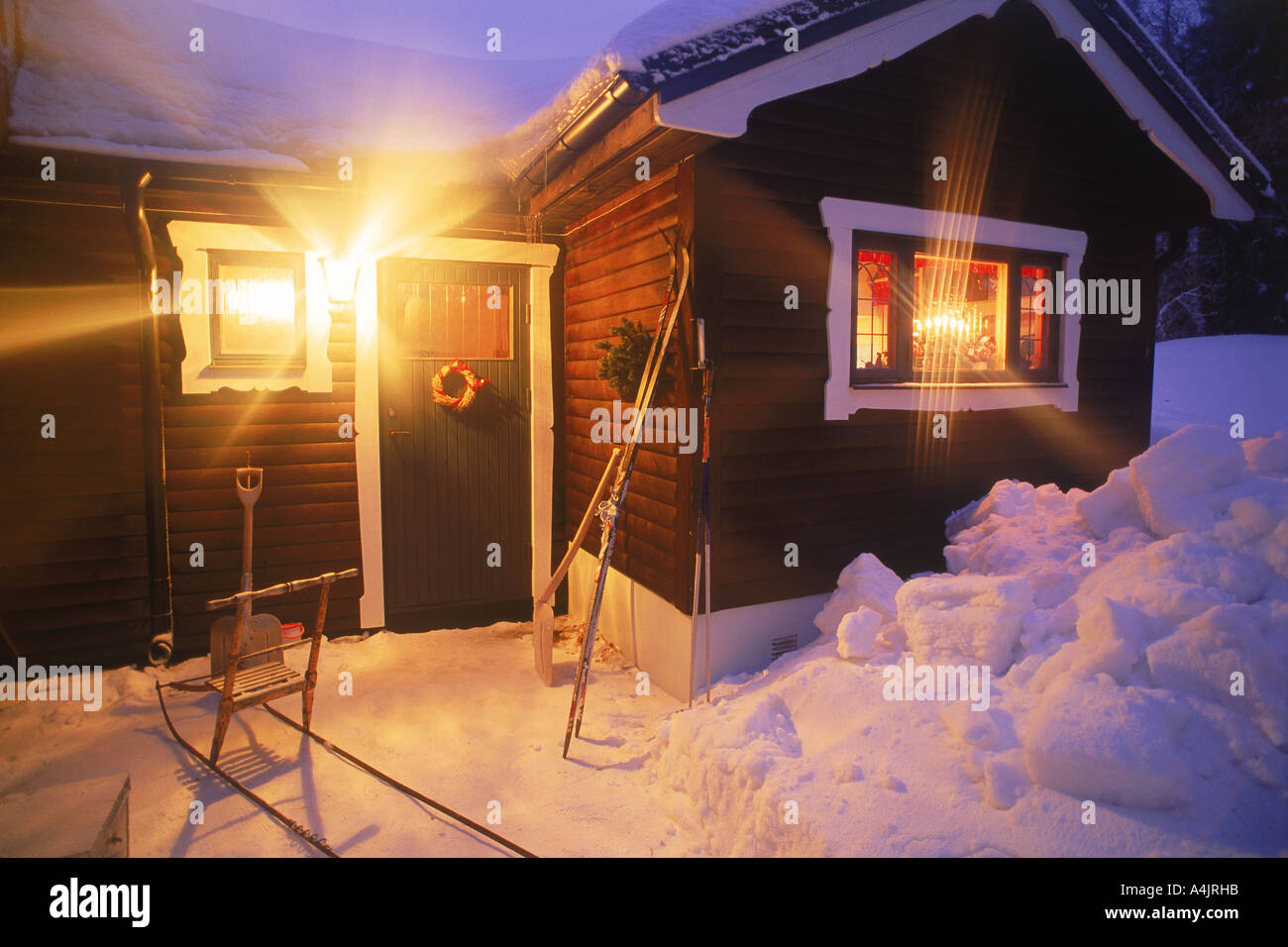 Country home en Dalécarlie, la Suède en hiver avec les skis, luge et des pelles sous Porch light Banque D'Images