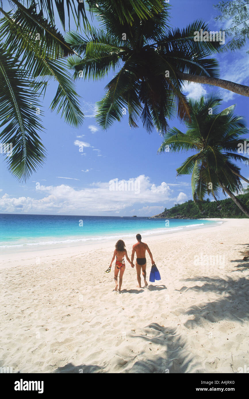 Couple avec nager à travers les ailettes de la plage de sable blanc de l'Intendance de l'île de Mahé aux Seychelles Banque D'Images