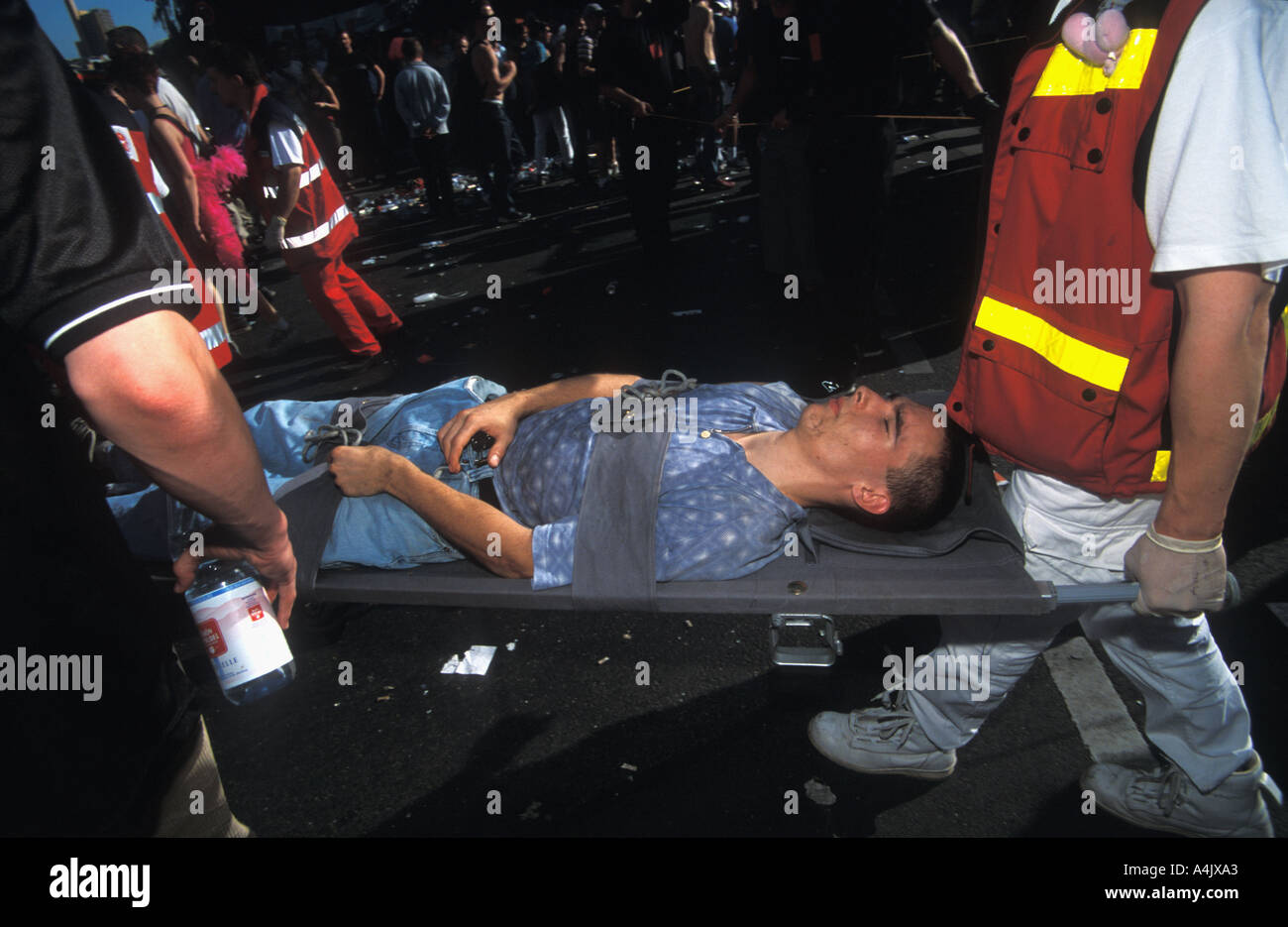 Un jeune homme inconscient est emmené sur une civière par ambulance men Love Parade Berlin Banque D'Images