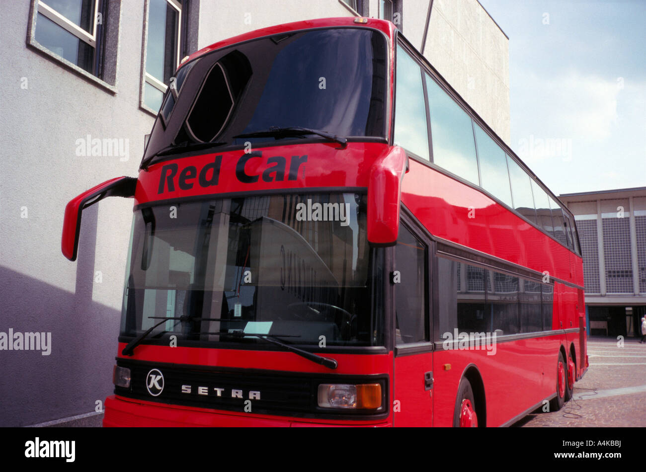 Un bus rouge avec voiture rouge écrit sur l'avant d'une voiture louer entreprise en Allemagne Banque D'Images