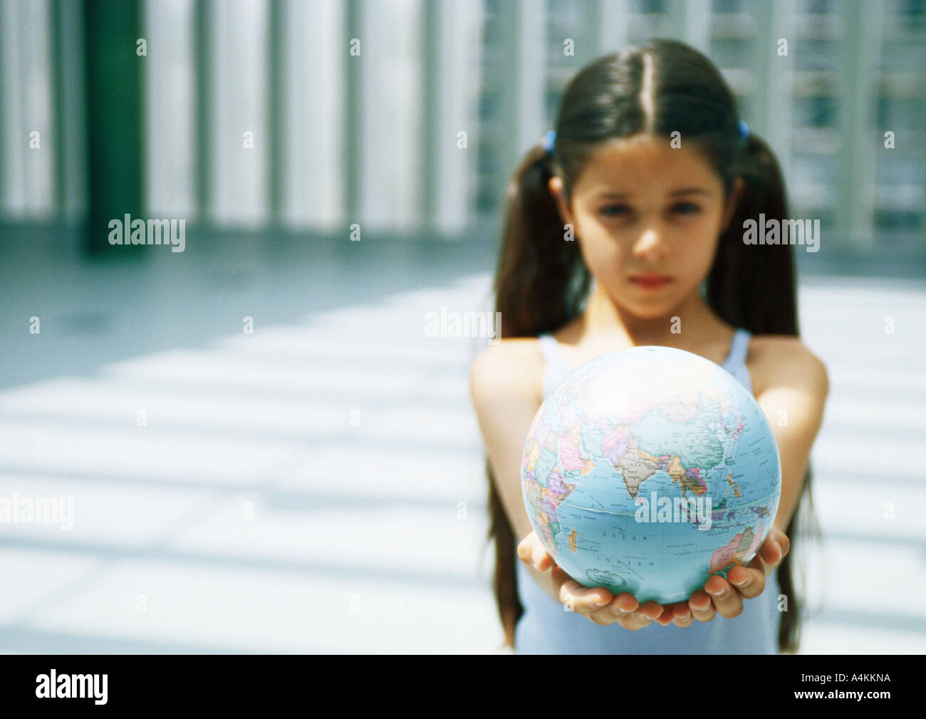 Girl holding out globe Banque D'Images