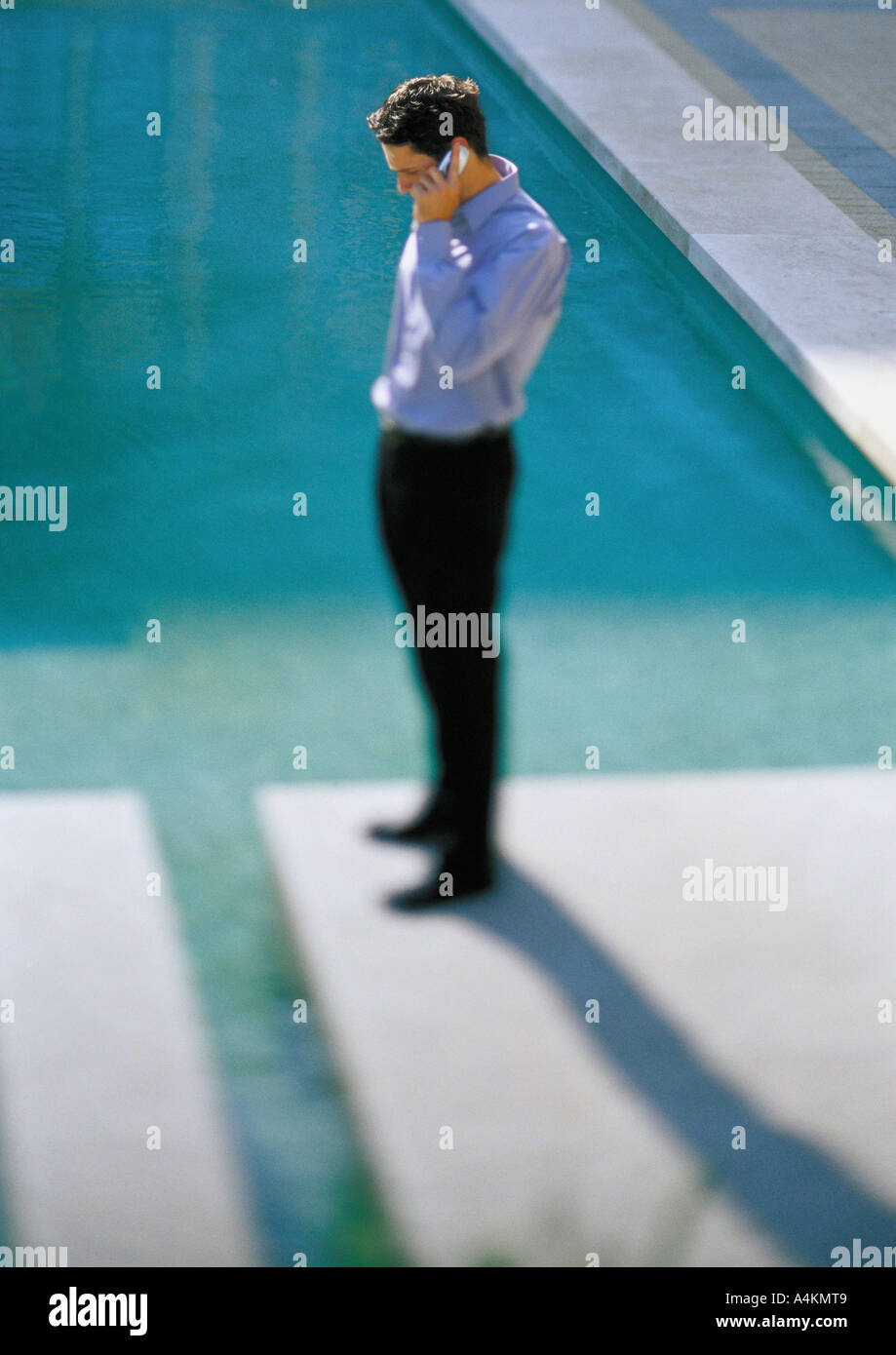 Homme debout dans le passage libre à côté de l'eau, l'utilisation de téléphone cellulaire Banque D'Images