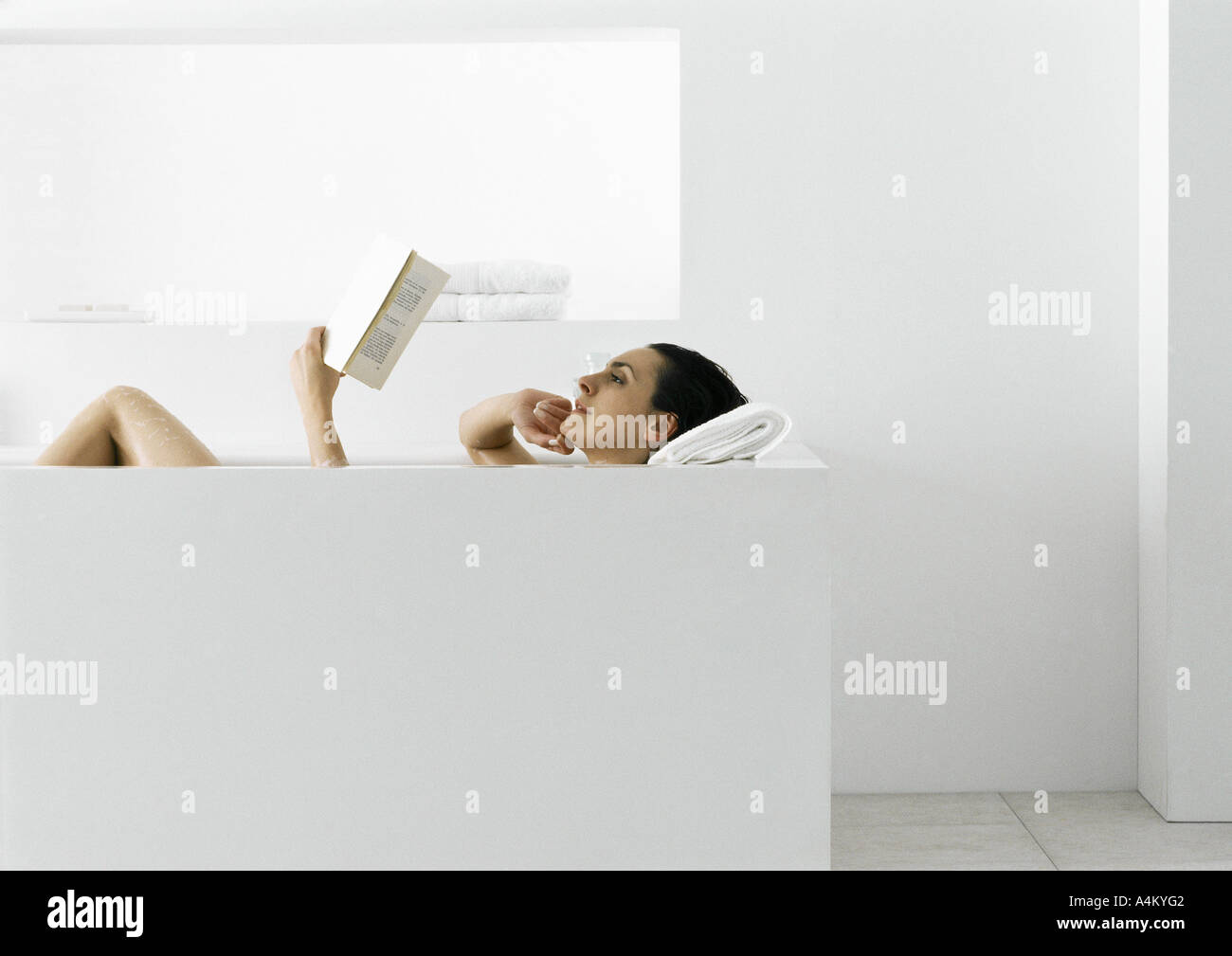 Femme lisant dans une baignoire Banque D'Images