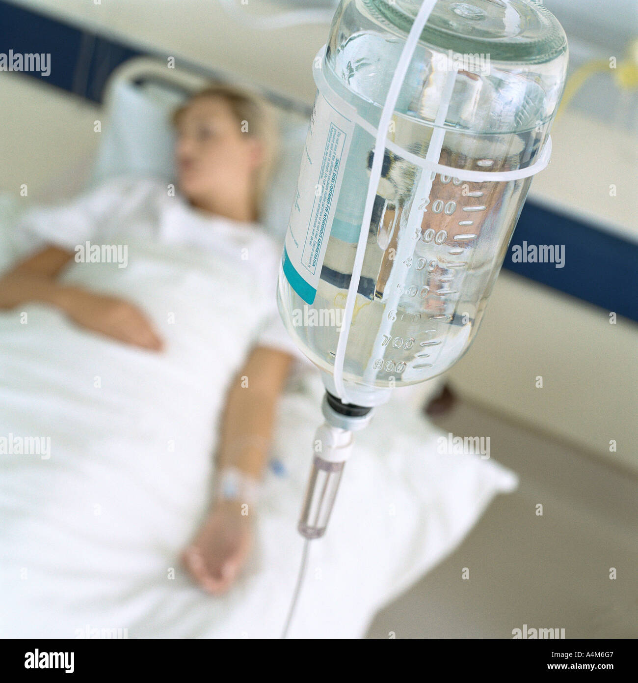 IV et female patient lying in hospital bed Banque D'Images