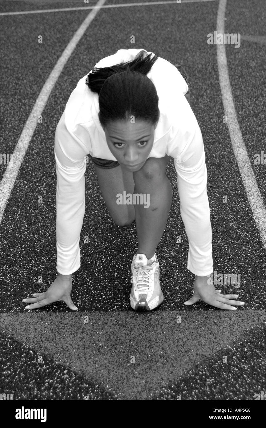 Black femme afro-américaine à la ligne de départ d'une course d'athlétisme Banque D'Images
